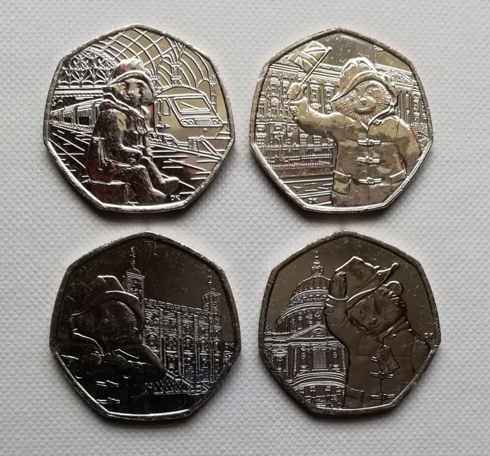 Clockwise Top Left - 2018 50p Paddington at the Station, 2018 Padding at the Palace, 2019 Paddington at St.Pauls, 2019 Paddinton at The Tower.