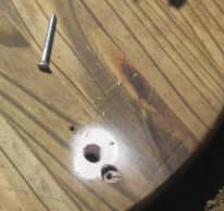 Toward the center is the hole used for your finger to align with the stake. The stake will be located below the counter sunk hole. A screw is driven easily into the stake with your power drill.