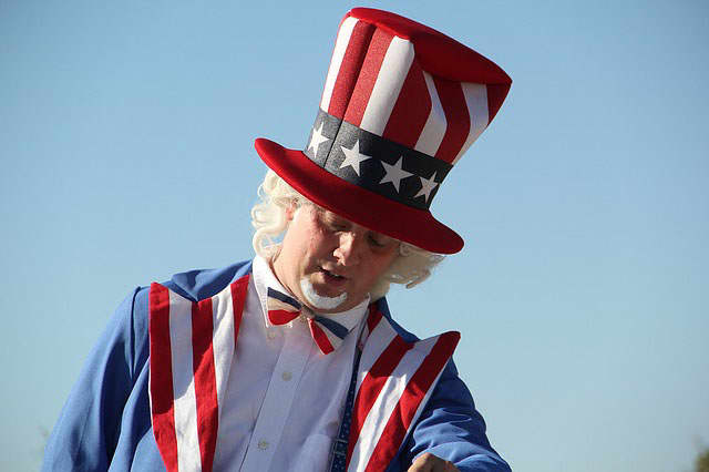 4th of July American symbol is a man dressed in red,white, and blue- colored suit which is topped off with a tall hat showing the stars and stripes representing the American flag. He is known as "Uncle Sam".