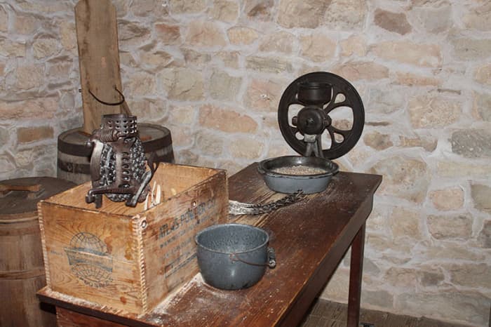 Wooden shipping boxes were often re-purposed for kitchen duty. This one is attached to a corn sheller.