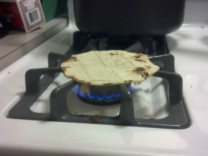 To cook corn tortillas, simply place over a clean gas burner and cook until charred in a few places. It may sound crazy, but it works.