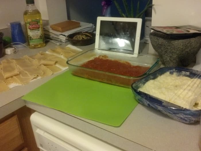 Laying out all of the ingredients can make it simpler and easier to form the lasagna rolls. From left to right: lasagna noodles on the paper towels drying, my baking pan with a layer of sauce ready to accept the rolls, and my filling. (Plus my iPad R