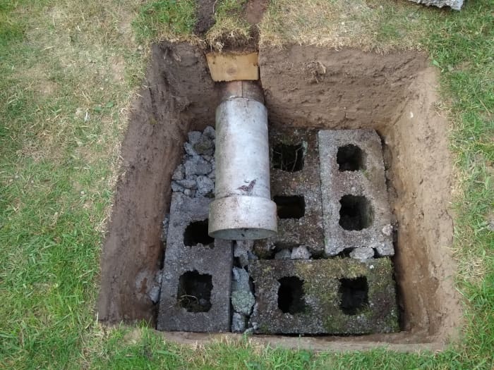 I used five layers of 9" blocks. A piece of waste concrete flue was used to extend the drain into the centre of the hole.
