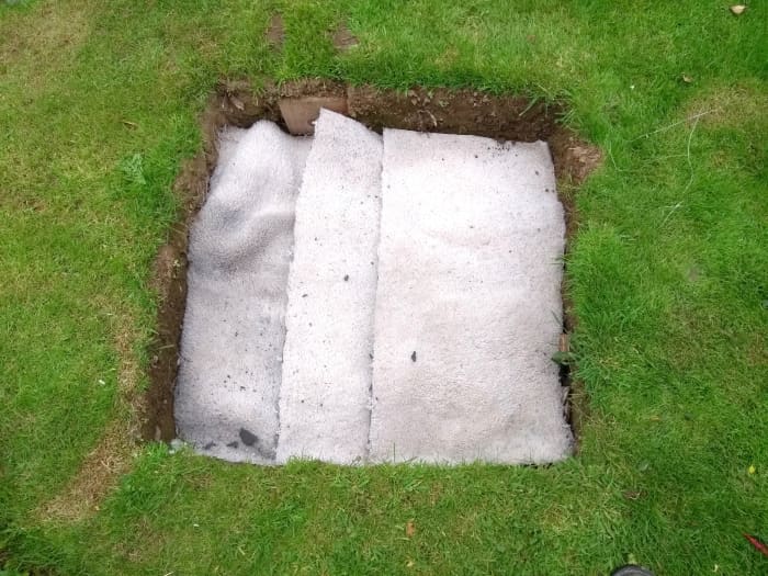 A piece of carpet hopefully will stop clay getting down into the drywell while still allowing water to drain through.