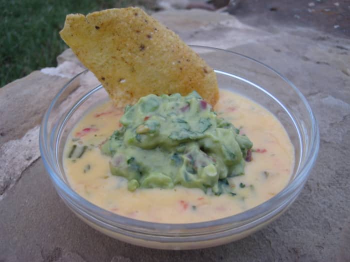 Spoon a shallow layer of queso into a small bowl, then place a scoop of guacamole in the middle of it. Yum!