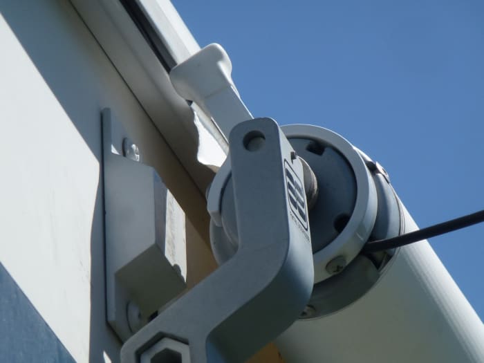 With the slide closed, the anti-billowing device will strike the stop on the RV and not allow the awning to unroll. Extending the slide out gives clearance for the device to turn. This one is on the drivers side at about the 11:00 position.