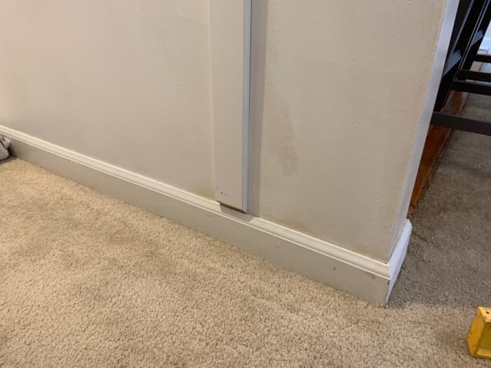 Installation of a vertical slat (1" x 3"). Note how the bottom of the slat is cut at a 45° angle to give nice transition to the bottom baseboard that already existed.