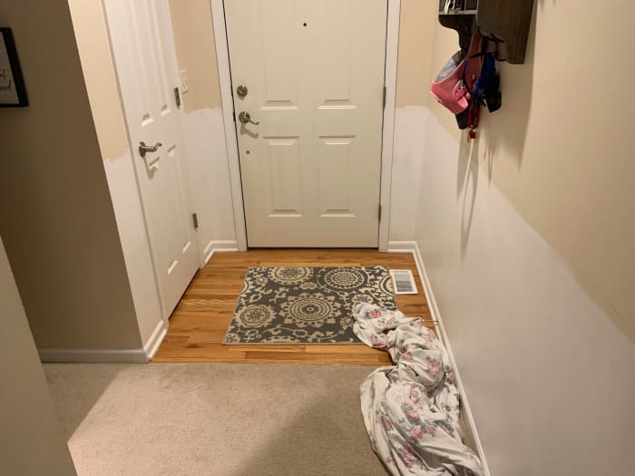 First step: Entryway area after it has been painted white and the height of the horizontal board has been measured. Also, at this point, we used a stud finder to locate the studs and marked the locations.