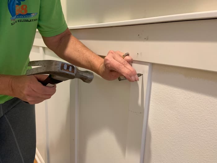 Using a countersink punch to the nails in the vertical slats. All the nails had to be countersunk into the wood so they could be painted over, thus making the final product smooth.