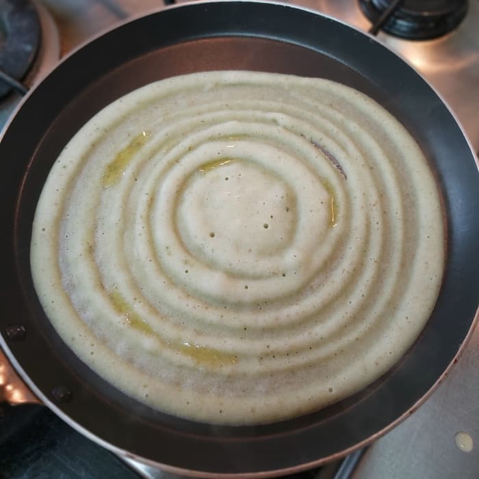 Smear a few drops of ghee on the dosa. Cover and cook on medium to low heat for about 1 minute or till it has cooked properly.