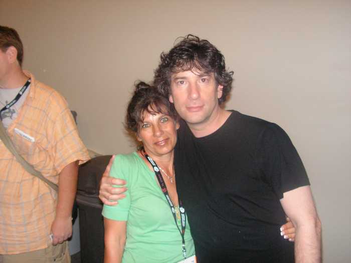 Really shitty picture of me and Neil Gaiman. But I am weaing green and an orangy/peachy lipstic.