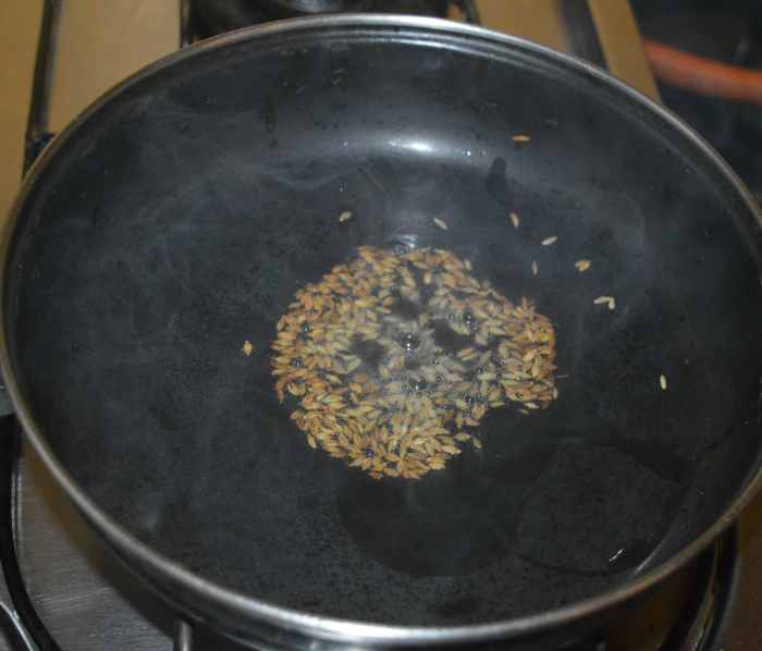 Heat oil in a deep-bottomed pan. Throw in the cumin seeds and allow them to crackle.