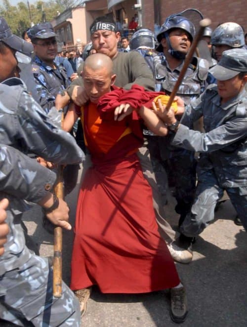 Tibetan monk struggling against Nepalese border guards.