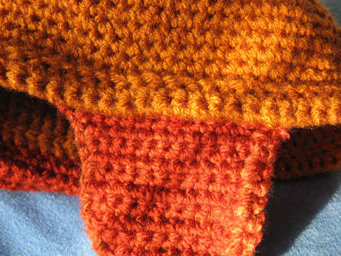 The ear flaps are attached to the inside bottom of the rolled brim. As you can see, I also crocheted around the edge of each ear flap to male it look nicer.