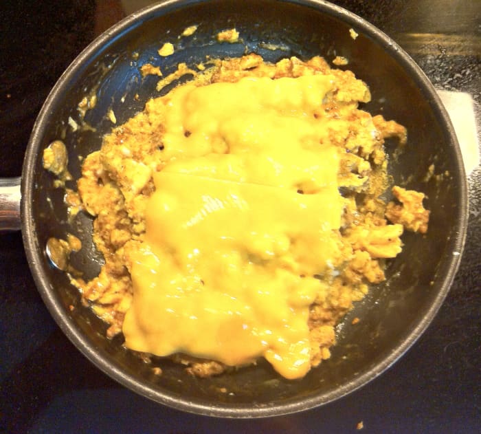 When cheese is melted, take off the lid and divide your mixture into quarters. Heat your tortillas and spread them out flat.