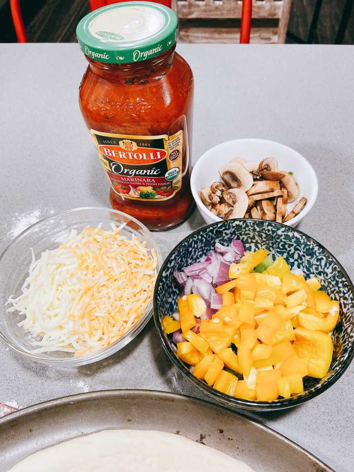 The toppings: marinara sauce, sliced veggies, and shredded cheese