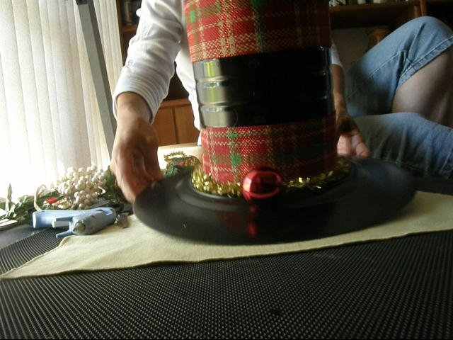 I glued the tinsel all the way around the bottom of the can so that the glue would not be visible. Make sure to remove strings of glue as they occur.