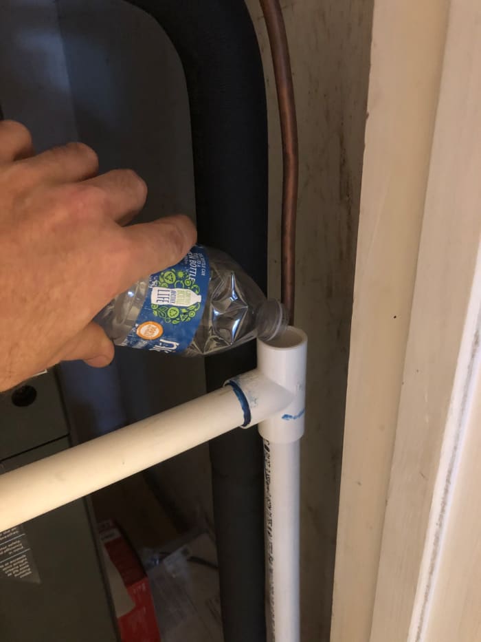 Use the service port to flush the drain with hot water. Doing this every time you change the air filter prevents sludge buildup.