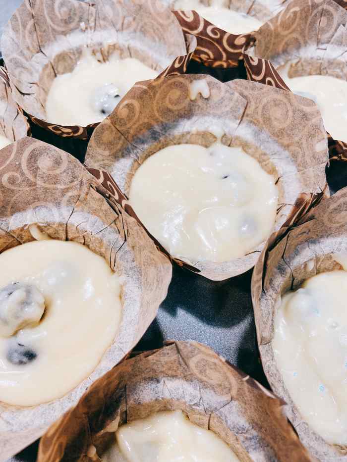 Using an ice-cream scoop, fill each muffin cup with batter.