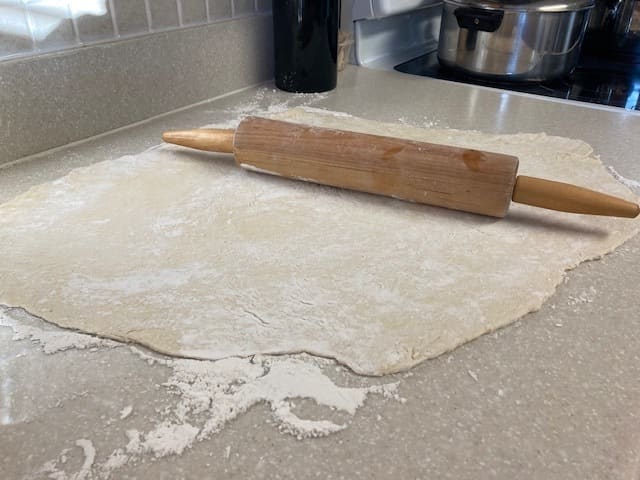 Roll the dough out until it is between 1/8 and 1/4 inch thick, depending on your preference for thinner or thicker noodles