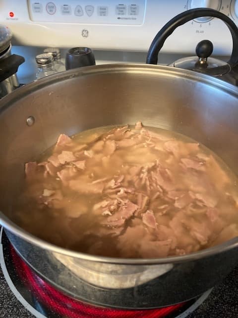 Add leftover ham and/or ham bone to the water and allow to simmer until meat separates easily. Remove the ham bone from the broth.