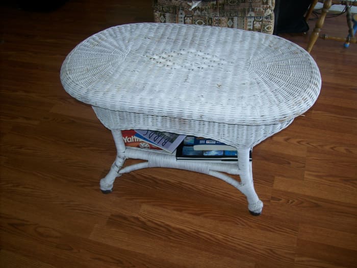 Wicker table that had a broken leg. Recovered from a dumpster. Cost: $3.00 for can of white spray paint and $1.00 for a small tube of epoxy.