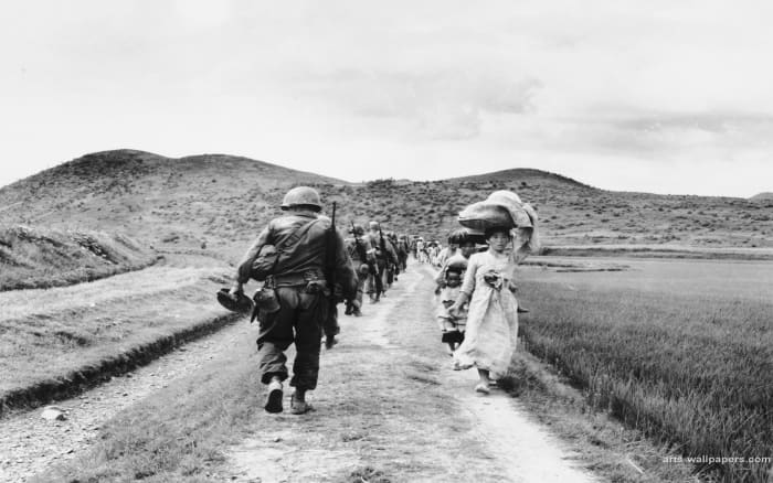 WHILE AMERICAN TROOPS HEAD NORTH, AN ENDLESS STREAM OF KOREAN CIVILIAN REFUGEES WALK SOUTH TO ESCAPE THE SOCIALIST ARMY