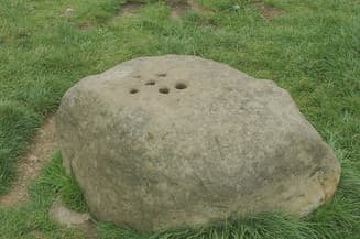 The Boundary Stone with holes drilled into the top to fill with vinegar to disinfect coins.