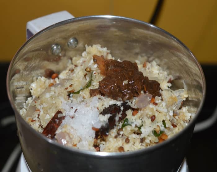 Step 2: When the mixture comes to room temperature, add it to a mixer jar. Add soaked tamarind, salt, and sugar. Grind, adding water as needed, to get semi-solid chutney. Transfer the chutney to a bowl.