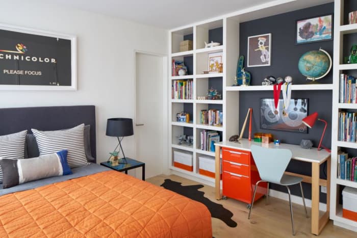 A teen's wall is storage with games, toys, books with a desk, a filing cabinet and plenty of shelving.