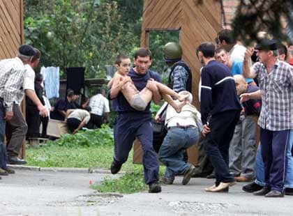 Unknown person rushing a child out of harm's way in Beslan school siege