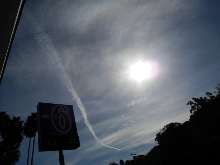 San Diego/ Approximately 10:30 am. This is a chemtrail that is morphing into a larger cloud like construct, but shown against an already Chemtrailed milky sky. Notice the consistency of the clouds in the background is different to REAL Clouds.