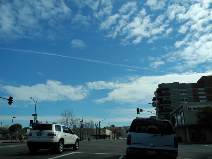 Pencil Thin Chemtrail Line placed among already existing Chemtrail Clouds which were dispersing into Key Hole Punch Clouds. Downtown San Diego... with the same key hole punch type Swiss Cheese Clouds in other pics.