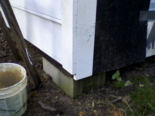 Detail of corner. The Harditrim boards will be cut off evenly at the bottom; you may be able to avoid this step by careful measuring. Note also the duct tape temporarily securing the tar paper.