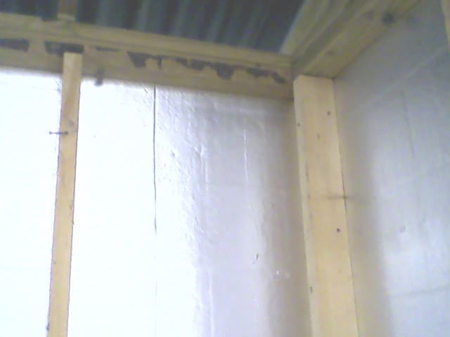 The inside view of the shed corner. Note how the stud on the right stands out from the intersecting wall, spaced away from it by the intersecting stud. No wood backs the siding board.