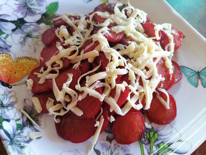 Cheesy hot dog with sauteed onions and ketchup