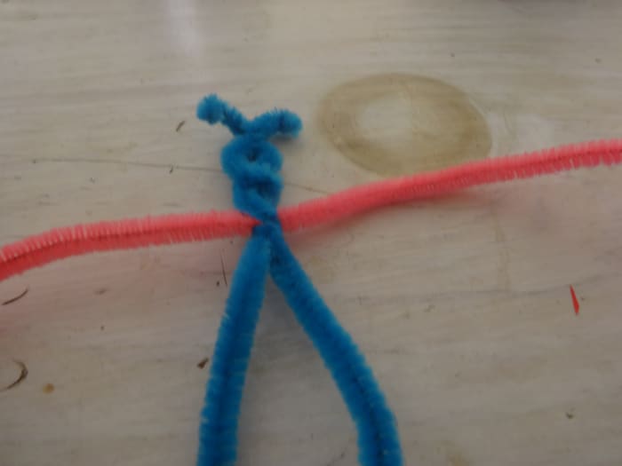 Thread another pipe cleaner through the first and so the middle goes through it and twist them together