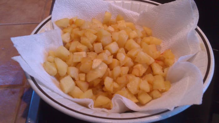 fried potatoes put on a lined bowl with kitchen paper to soak up excess cooking oil