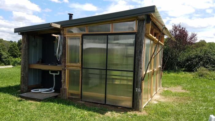 This multi-purpose garden shed combines a greenhouse, dehydrating shed, and outdoor kitchen into one building.