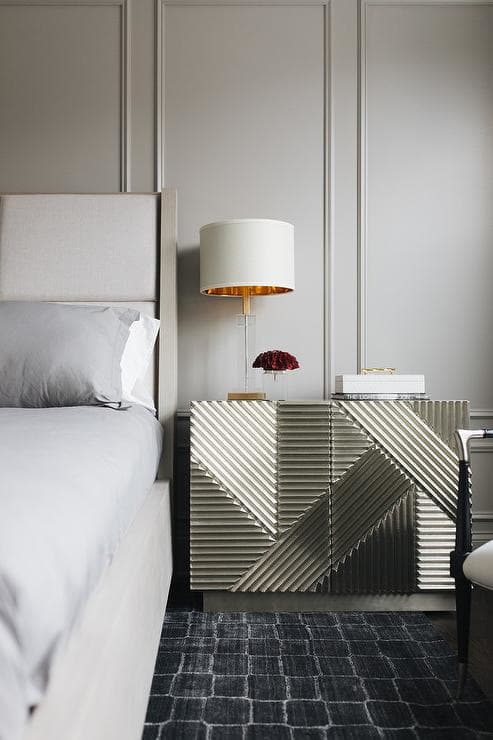 The bed wingback upholstered is the silver nightstand with the gold lamp. The rug is the gray wainscoted wall and the bedding gray sheets and comforter.