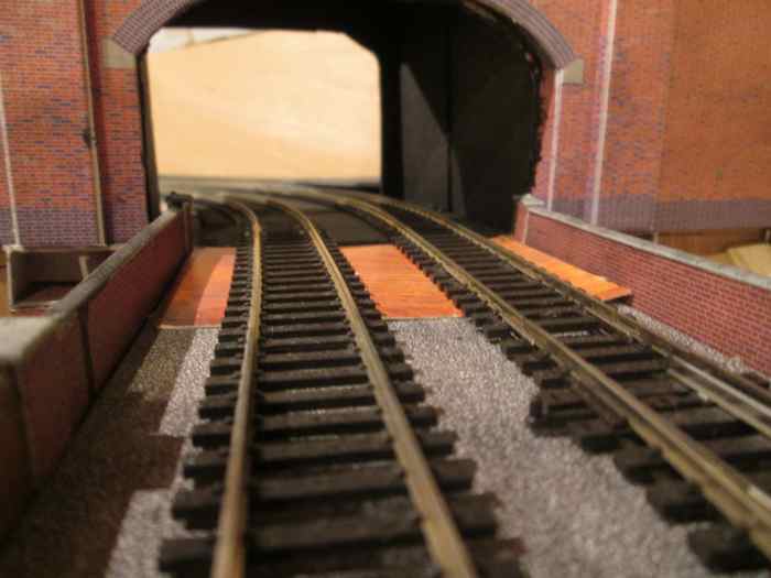 Off the layout and into Unit 7 fiddleyard through the baffle - added on the curve to simulate the entrance to a short tunnel and give the eye a sense of continuity instead of a jarring scenery break