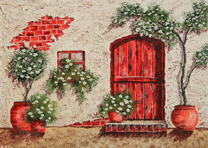 A red door entry to a country cottage framed with greenery in red planter pots on either side of the door.