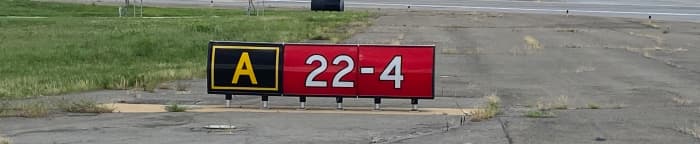 This taxiway/runway hold short sign explains that you are located on taxiway Alpha holding short of runway 4/22.