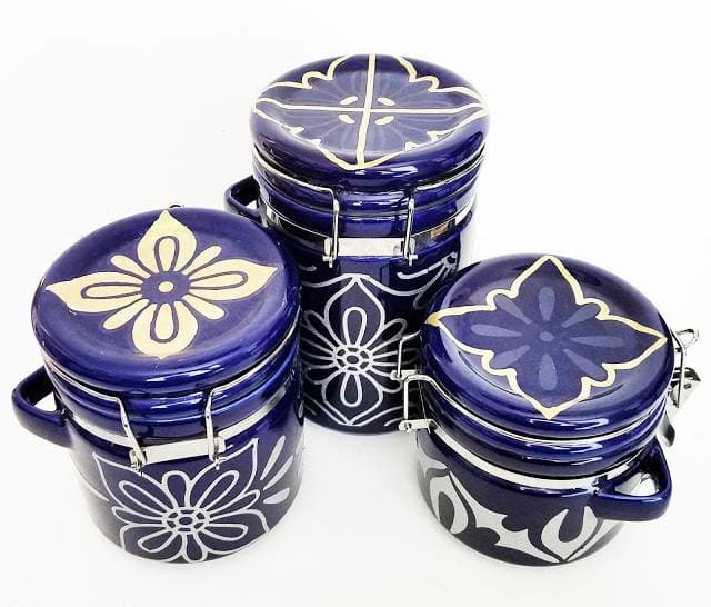 Cut a piece of self-adhesive contact paper or wallpaper. Peel off the backing and wrap around the canisters.