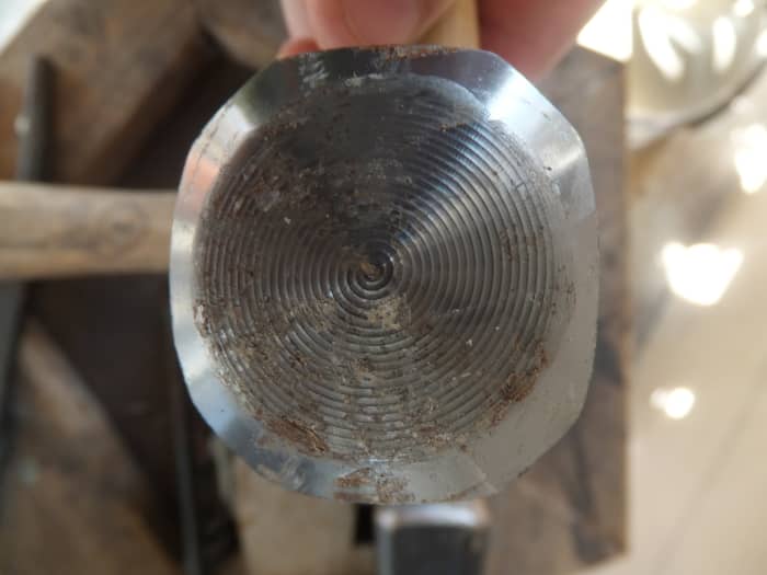 Ridges in blacksmith hammer need to be ground off so that it will strike cleanly. Otherwise these ridges will be imprinted in your work.