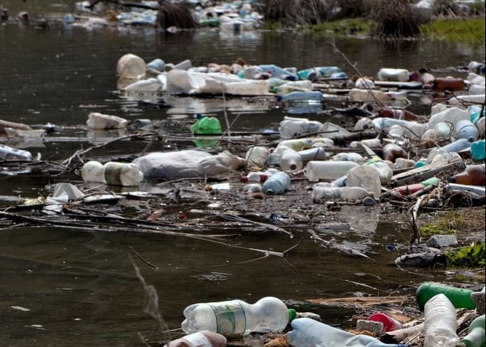 Plastic bottles and other items littering the banks of this river is an example of nonpoint source pollution.