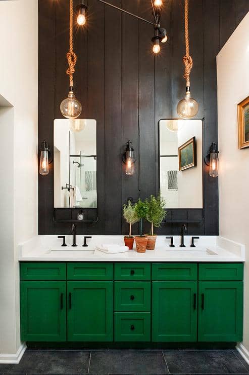 The vanity with emerald green paint and black on the wall. The top white counter and oil-bronze hardware.