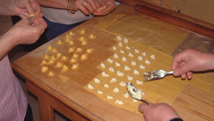 Cappelletti (Emilia Romagna). Made by stuffing squares of egg pasta, folding them in a triangle, and then joining the two ends around a finger. They are cooked in chicken broth and eaten as soup.