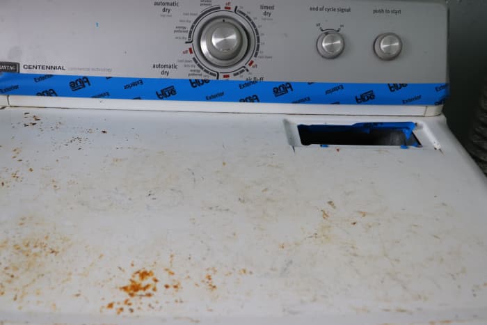 Prevent paint overspray from entering the lint trap or damaging the control panel with the use of painter's tape.
