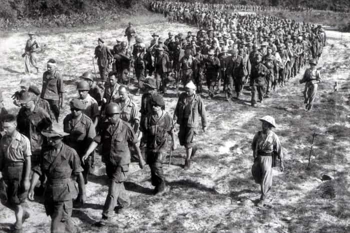 Captured French soldiers from the battle of Dien Bien Phu, escorted by Vietnamese troops, walk to a prisoner-of-war camp